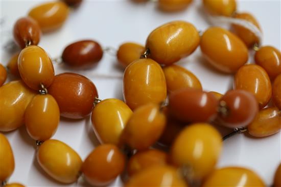 A single strand graduated oval amber bead necklace, 95cm.